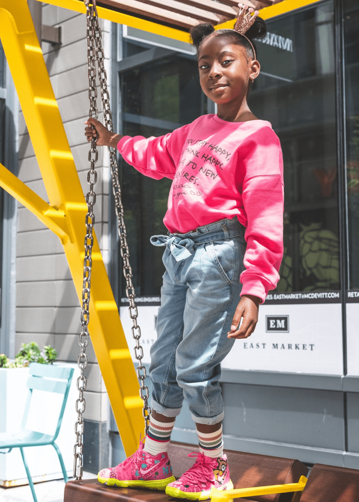 Stylish kid with colorful sneakers on swing.